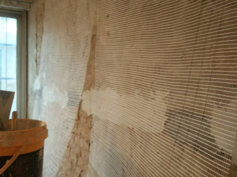 墙面挂网抹灰：挂网抹灰应分层进行。加气混凝土砌块外墙体，应先挂网，用50#水泥钉固定牢固，固定钉与砼面间采用强力万能胶粘结，每200mm间距贴一个，绷紧钢丝网；搭缝宽度从缝边起每边不得小于125mm。墙面加气混凝土块刷好掺用水量10%的建筑胶素水泥浆以后应及时抹灰，不得在素水泥浆风干后再抹灰，否则，形成隔离层，不利于基层粘结。对于加气块与混凝土柱梁面交接的部位，加强网的搭接宽度不应小于100mm。第一遍抹砂浆，配合比为1∶3，厚度5mm，扫毛或划出纹线，养护，特干后，抹第二遍，用大杠将墙面刮平，木抹子搓平。用托线板检查，要求垂直、平整，阴、阳角方正，顶板（梁）与墙面交角顺直，管后阴角顺直、平整、洁净。